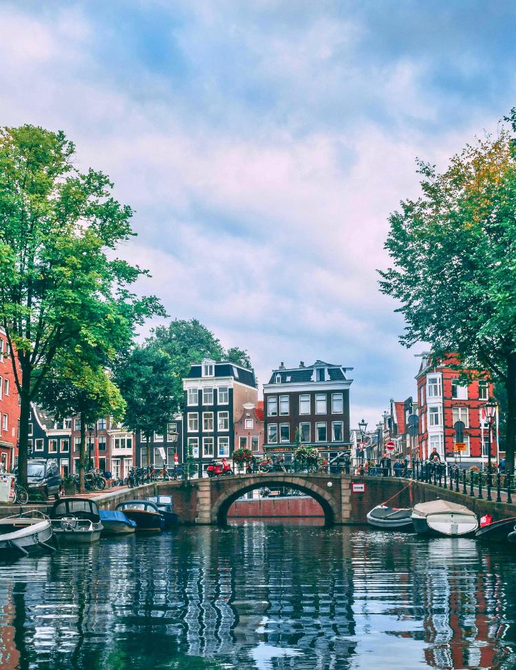 La città di Amsterdam con vista sulle barche parcheggiate sul fiume Amstel