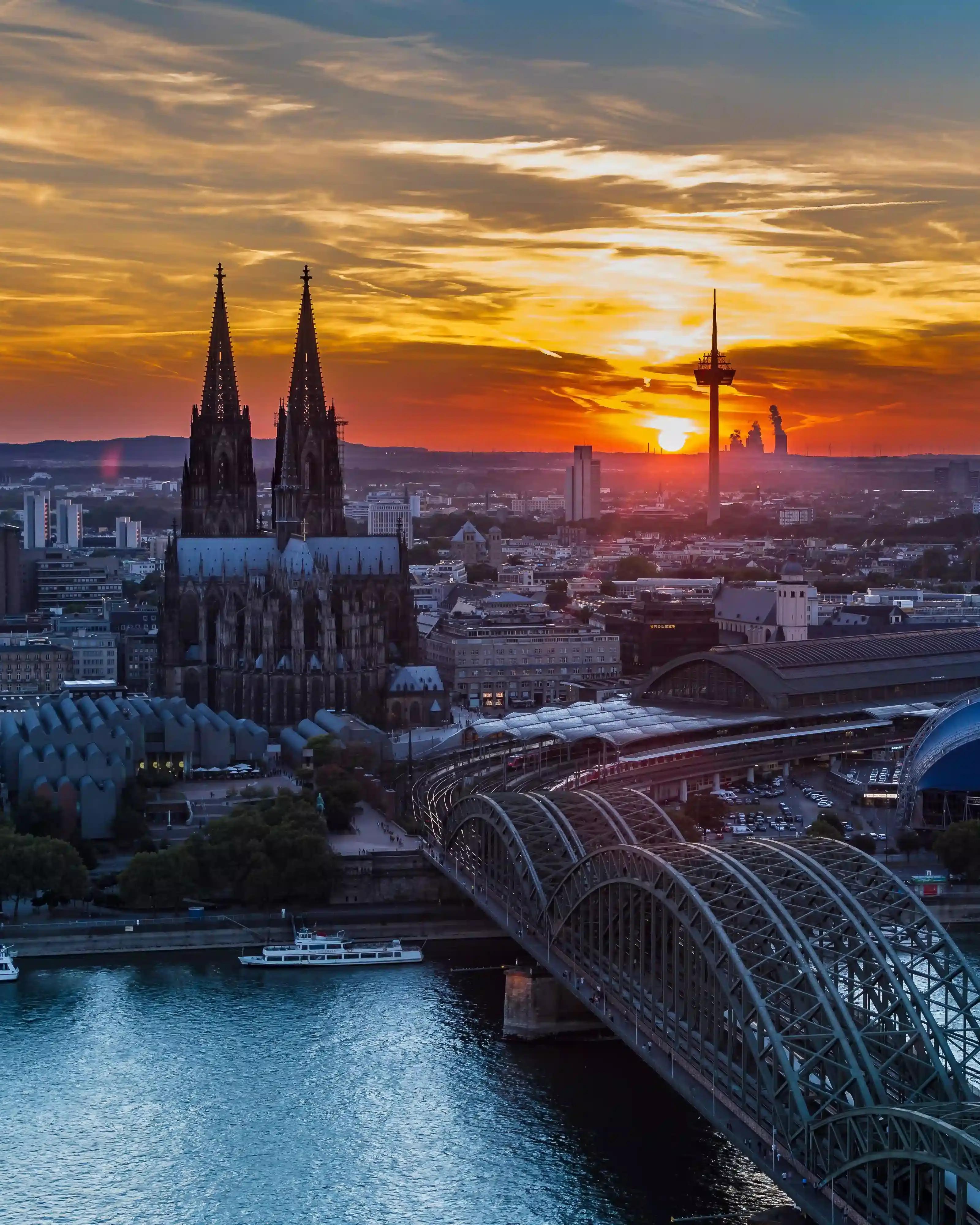 A sunset view of Cologne with the Cologne Cathedral and the Hohenzollern Bridge